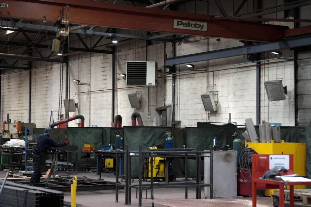 a warehouse with 4 X-Heat heaters on back wall, which is a white brick wall.