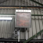 A wall-mounted nano-heater that's shaped like a rectangle with a vent cover on the front of it, and above the vent cover is text reading 'X-HEAT'.