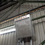 x-heat nano-heat heater mounted on a grey metal wall, the image is taken from a high angle.