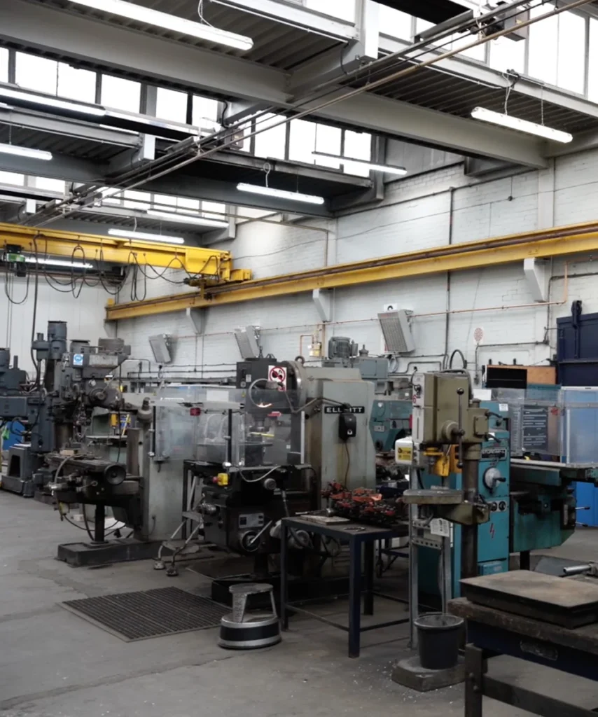three nano-heaters attached to the wall in the distance, they have copper piping going through them, they are under a overhead crane.